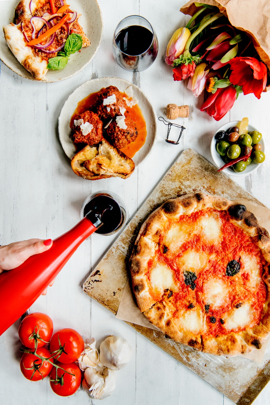 Original LYONS photograph: red wine being poured beside fresh pizza